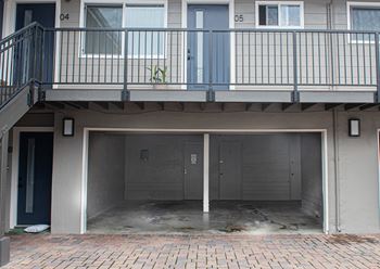A building with a balcony and a garage.